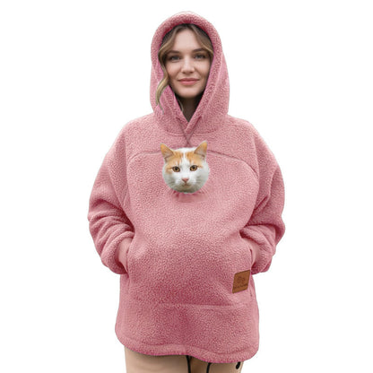 Cat in the pouch of a pink Pawdie hoodie